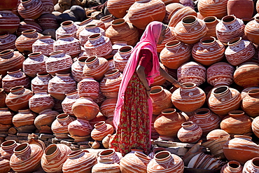 Indian woman selling clay water pots on sale in old town Udaipur, Rajasthan, Western India,