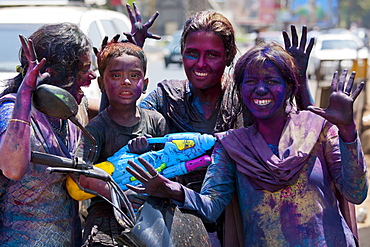 Indian woman and child celebrating annual Hindu Holi festival of colours with powder paints in Mumbai, formerly Bombay, Maharashtra, India