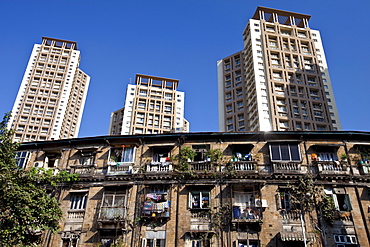 Old traditional tenement housing in the shadow of new modern high rise apartment blocks at Mahalaxmi in Mumbai, Maharashtra, India