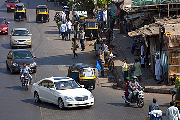 Mercedes S Class luxury saloon and auto rickshaws among traffic in Bandra near BKC Complex in Mumbai, India