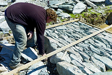 Workers pitching a path using Elterwater green slate, near Easedale Tarn in the Lake District National Park, Cumbria, UK