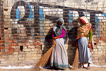 Women sweeping the street in Agra, India.