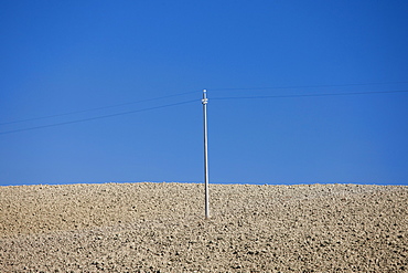 Telegraph pole in barren landscape at Murlo in Tuscany, Italy