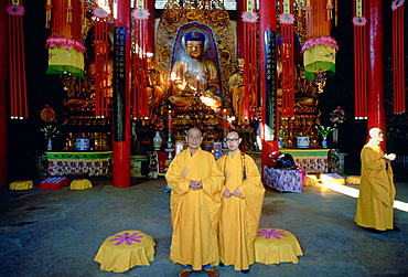 Buddhist monks in saffron coloured robes at the Buddhist Temple in Huating, Kunming, China