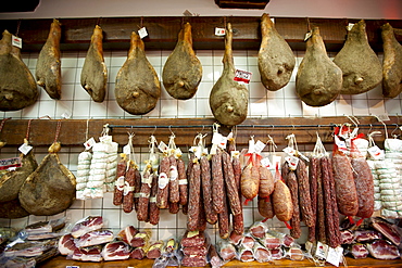 Italian artisan food shop, Cacio Di Pienze, selling pork salami, prosciutto and cured sausages in Pienza, Tuscany, Italy