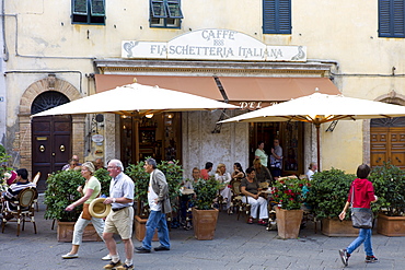 Diners eat al fresco at restaurant and bar Caffe 1888 Fiaschetteria Italiana in Piazza del Popolo, Montalcino, Val D'Orcia,Tuscany, Italy