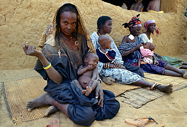 Mothers and children sitting on mats while waiting at Gorom Gorom Hospital in Burkina Faso (formerly Upper Volta)