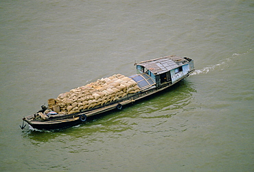 Cargo being transported in sacks in a barge along the Pearl River, Canton, China