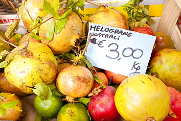 Fresh pomegranate fruit, melograne, on sale at weekly street market in Panzano-in-Chianti, Tuscany, Italy