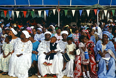 Gambians smartly dressed sitting with their children while watching an Independence Day parade in Banjul, The Gambia, West Africa.