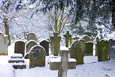 Snow-covered gravestones in Hampstead Parish Graveyard in Church Row and Holly Place in Hampstead, North London, UK