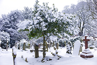 Snow-covered gravestones in Hampstead Parish Graveyard in Church Row and Holly Place in Hampstead, North London, UK