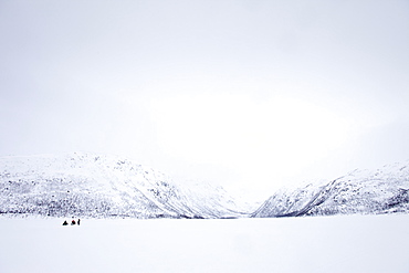 Ice fishing on frozen lake in the arctic alps in the Arctic Circle on Ringvassoya Island in the region of Tromso, Northern Norway