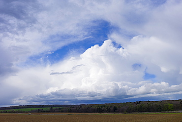 Cloud formation Cumulus, Towering Cumulus (centre) and Cumulonimbus above agricultural land at Swinbrook in the Cotswolds,  UK