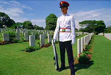 Soldier standing on guard over Commonwealth war graves at Krangi War Cemetery in Singapore