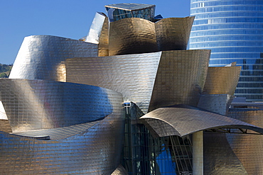 Architect Frank Gehry's Guggenheim Museum futuristic design in titanium and glass and Iberdrola Tower behind at Bilbao, Spain