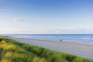 Couple stroll along deserted and peaceful Utah Beach, scene of the D-Day Landings,  in Normandy, France