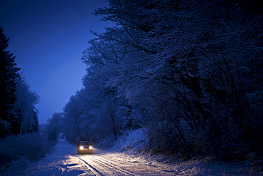 Four wheel drive car in traditional snow scene in The Cotswolds, Swinbrook, Oxfordshire, United Kingdom