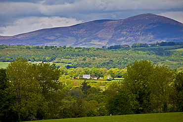 Farmhouse and distant view of Knockmealdown Mountains at Glengoura, County Cork, Ireland