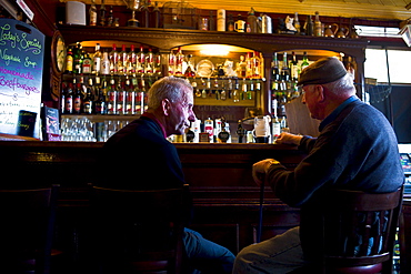 Locals drinking Guinness and beer in traditional Crotty's bar during horse fair, Kilrush, County Clare, West of Ireland