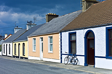 Street scene  pastel painted terraced bungalows and bicycle in Railway Road, Kilkee, County Clare, West of Ireland