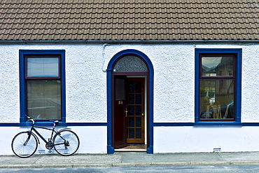 Street scene white pebbledash terraced bungalow and bicycle in Kilkee, County Clare, West of Ireland