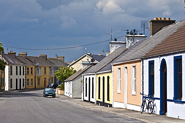 Street scene  pastel painted terraced bungalows and bicycle in Railway Road,  Kilkee, County Clare, West of Ireland