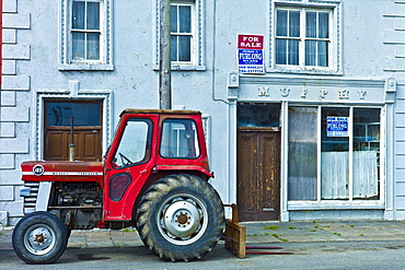 Tractor parked at  Murphy shop with estate agent For Sale boards in, Kilkee, County Clare, West of Ireland