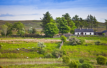 Farmhouse home nestling at the foot of the Maumturks  mountains, near Recess, in Connemara, County Galway, Ireland