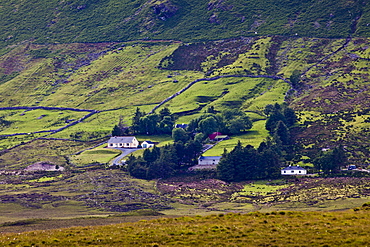 Homes nestling at the foot of the Twelve Bens mountain range in Connemara National Park, County Galway, Ireland