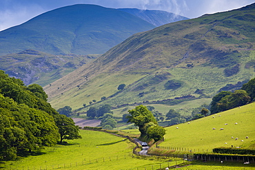 Car motoring along winding road through picturesque valley at Llanfihangel, Snowdonia, Gwynedd, Wales