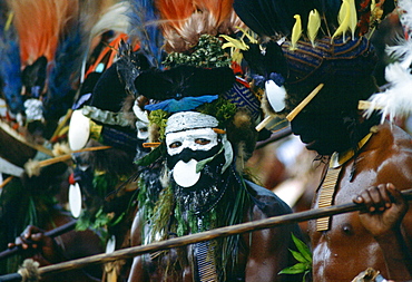 Bearded tribesmen wearing war paints and feathered headdress during  a gathering of tribes at Mount Hagen in Papua New Guinea