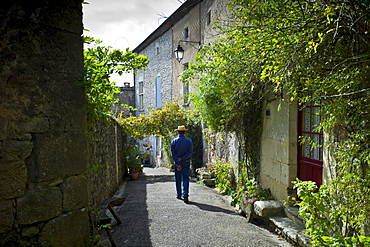 Man strolls in quaint town of Castelmoron d'Albret in Bordeaux region, Gironde, France