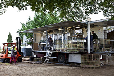 Wine bottling truck with mobile bottling line at Chateau Fontcaille Bellevue vineyard in Bordeaux region of France