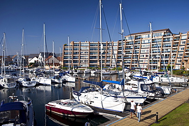 People passing yachts and power boats moored at Port Solent marina, near Portsmouth, South Coast of England, UK