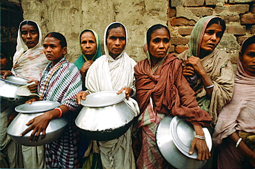 Women carrying pots in early morning food queue at Mother Teresa's Mission in Calcutta, India