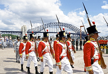 Carnival parade in costumes for celebrations at Sydney Opera House by Sydney Harbour Bridge for Australia's Bicentenary,1988