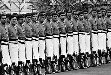 Soldiers in traditional uniforms wearing skirts in military parade in Fiji, South Pacific