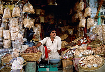 A man in Islamabad, Pakistan working in his shop selling fruit and nuts