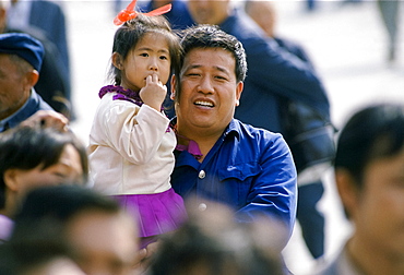 Chinese father and child among the crowds in Tiananmen Square in Peking, now Beijing, China in the 1980s