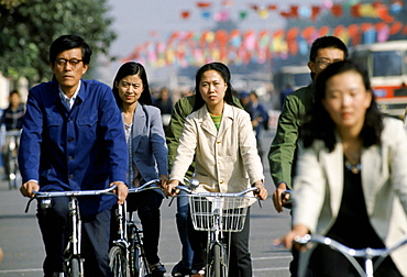 Chinese people using traditional bicycles for commuting in Peking, now Beijing, China in the 1980s