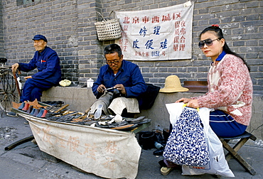 Chinese cobbler making and repairing shoes in backstreets of Peking, now Beijing, China in the 1980s