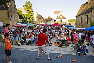 Juggler at village fete traditional festival in St Genies in the Perigord region,  France