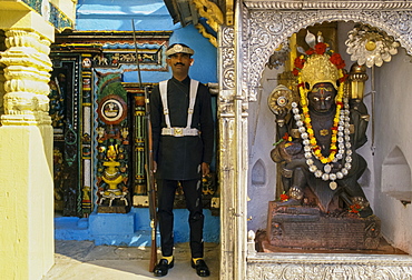 Ceremonial guard and garlanded religious statue, Kathmandu, Nepal