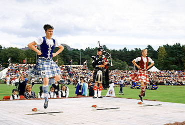 Scottish girls in tartan kilts dancing the sword dance at the Braemar Royal Highland Gathering, the Braemar Games in Scotland