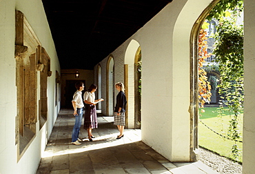 Students chatting in cloisters at Jesus College, Cambridge University, England, UK