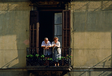 Elderly man and woman watching from the balcony of their home in Seville,Spain