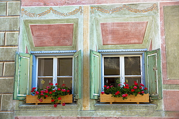 Windows in old painted stone 17th century building in the Engadine Valley in the village of Guarda, Graubunden, Switzerland, Europe