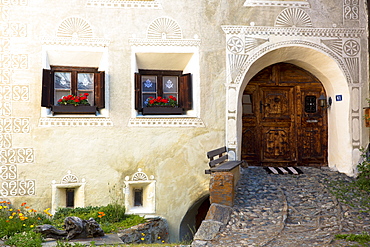 Windows in old painted stone 17th century building in the Engadine Valley in the village of Guarda, Graubunden, Switzerland, Europe