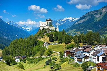 Tarasp Castle surrounded by larch and pine forest in the Lower Engadine Valley, Switzerland, Europe